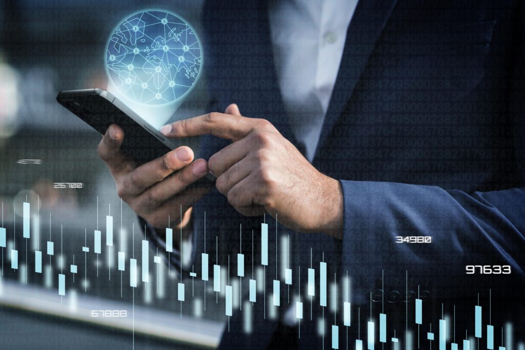 A professional using a smartphone with overlaying graphics of a glowing globe and financial data charts