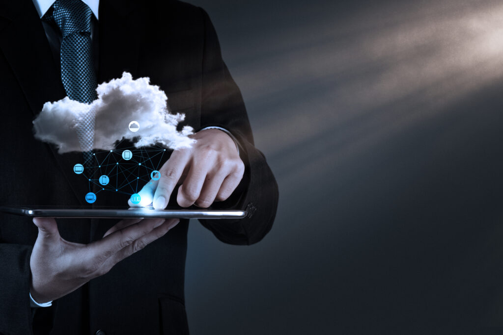 Business professional interacting with a tablet, visualizing a cloud computing network