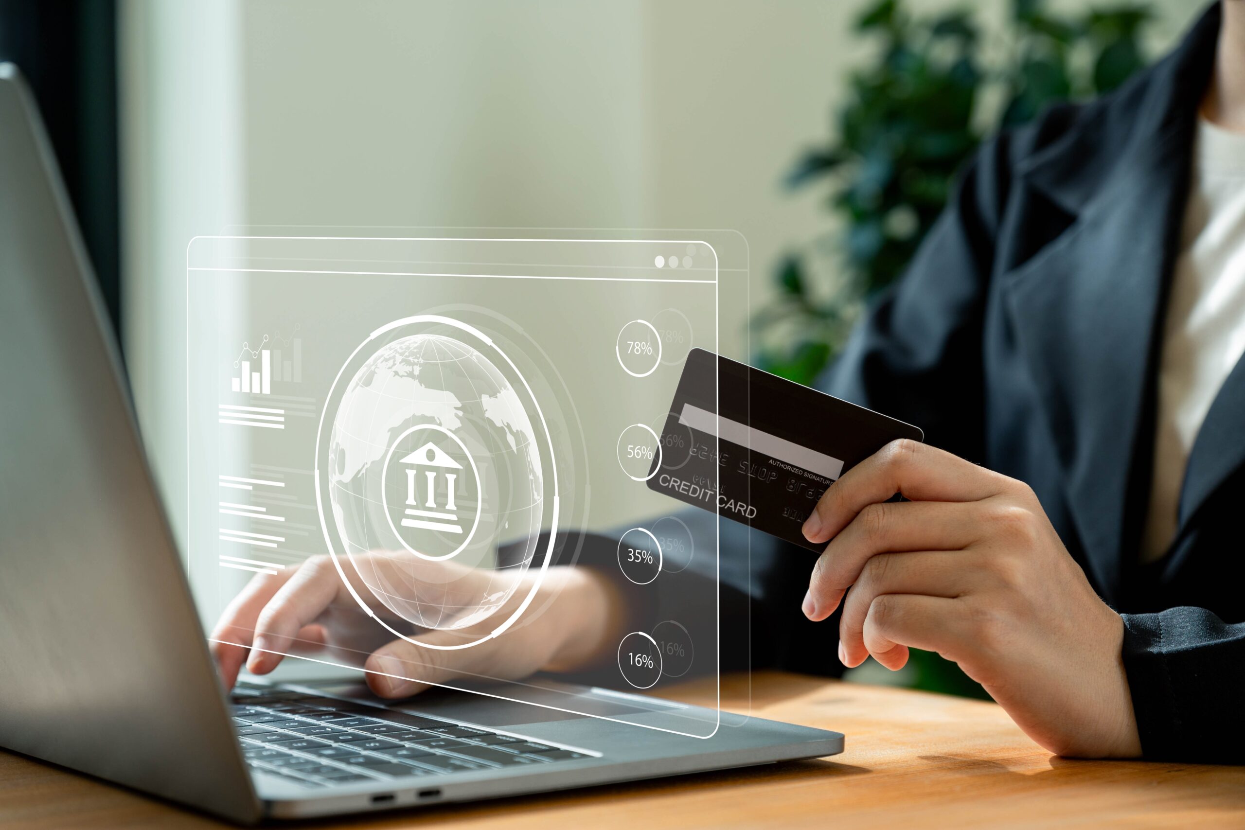 A person making an online payment with a credit card, while a holographic financial interface displays banking and transaction data, representing AI-powered fraud detection and secure digital transactions