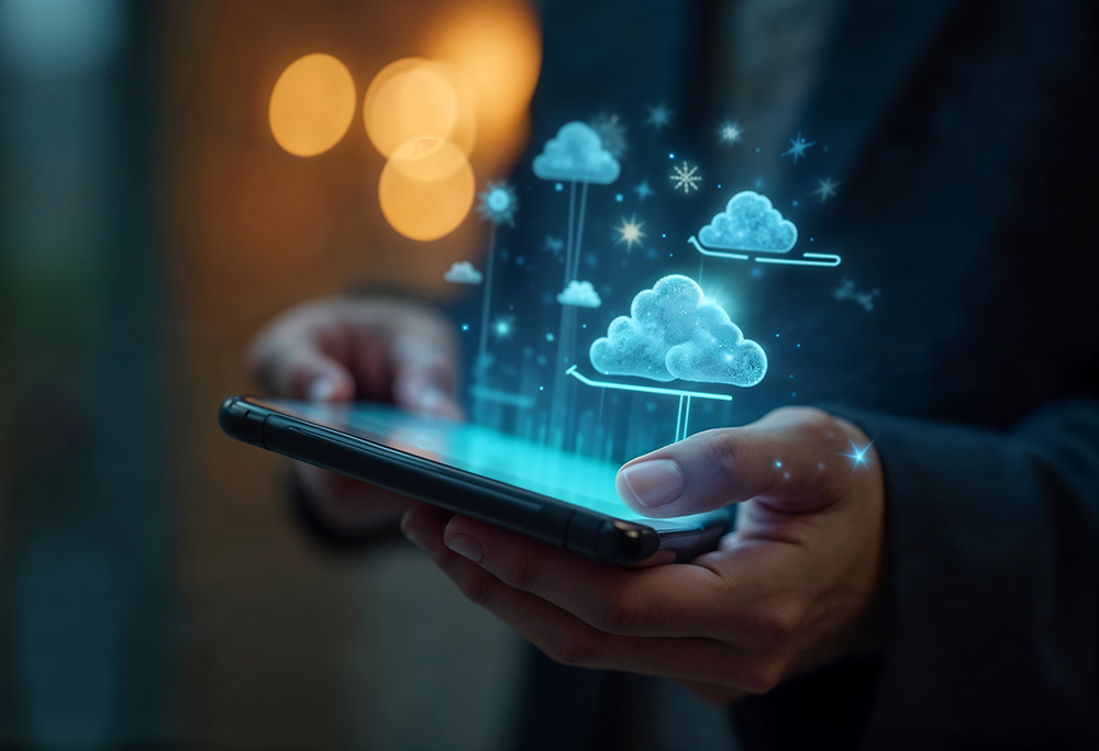 Business professional holding a smartphone with glowing holographic cloud icons floating above it, representing cloud computing, multi-cloud governance, and AI-powered compliance solutions.