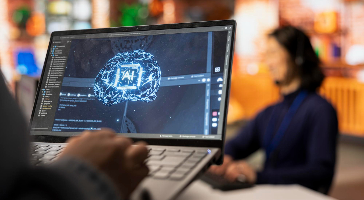 A person using a laptop displaying a digital illustration of an AI brain with code and neural graphics on the screen, symbolizing artificial intelligence development and data training.