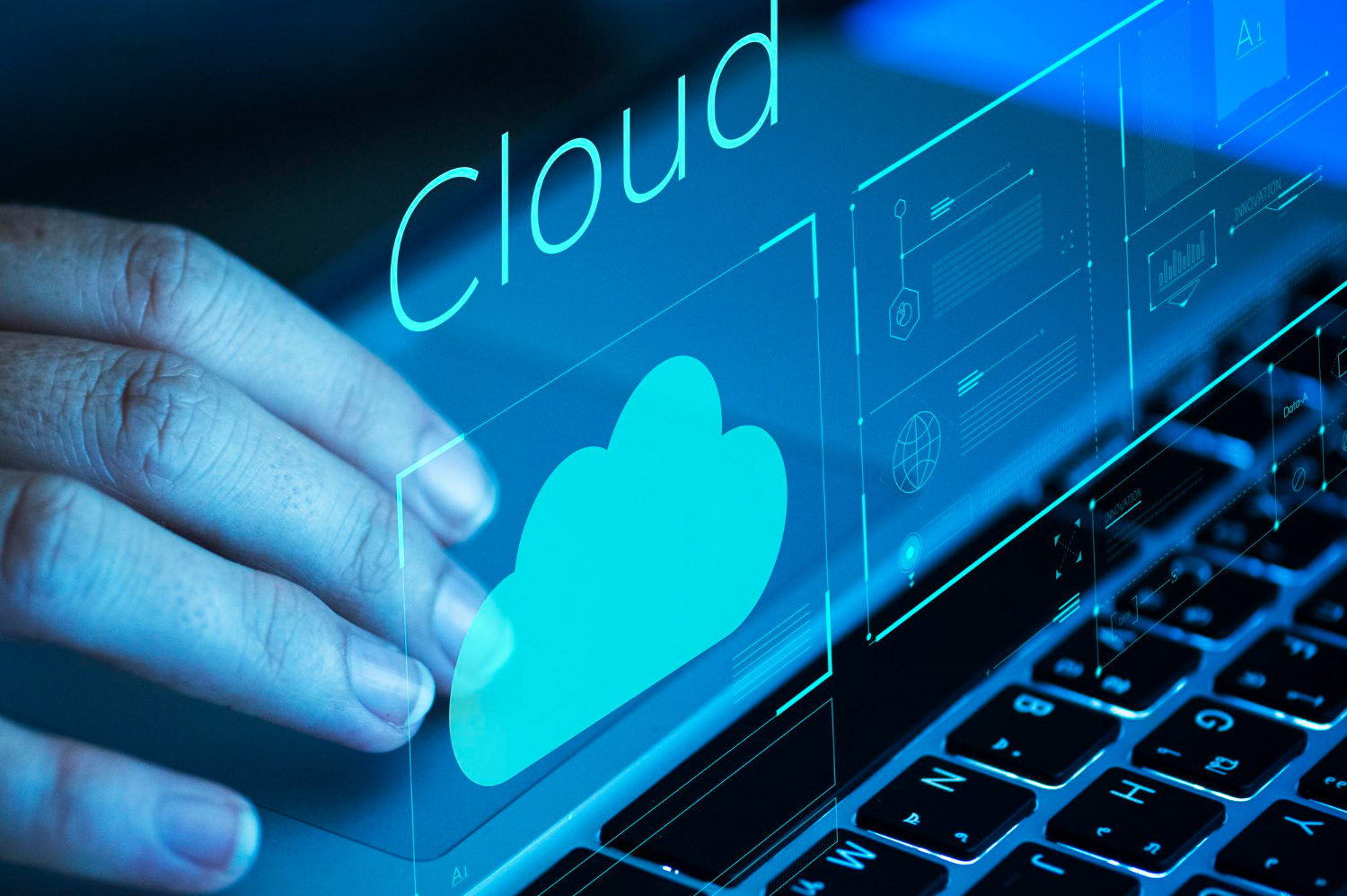 A person interacts with a glowing digital cloud icon projected above a laptop keyboard, symbolizing cloud computing, data storage, and online infrastructure management.