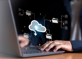 Person using a laptop with cloud migration icons showing files and folders moving to the cloud, symbolizing cloud migration consulting.